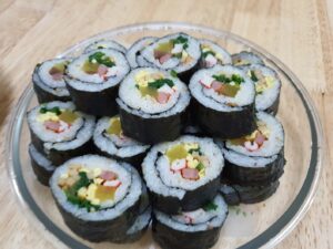 부드럽고 다채로운 계란김밥 조각이 접시에 가지런히 놓여 있는 모습